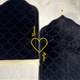 Two black prayer mats with gold embroidery on a marble floor.