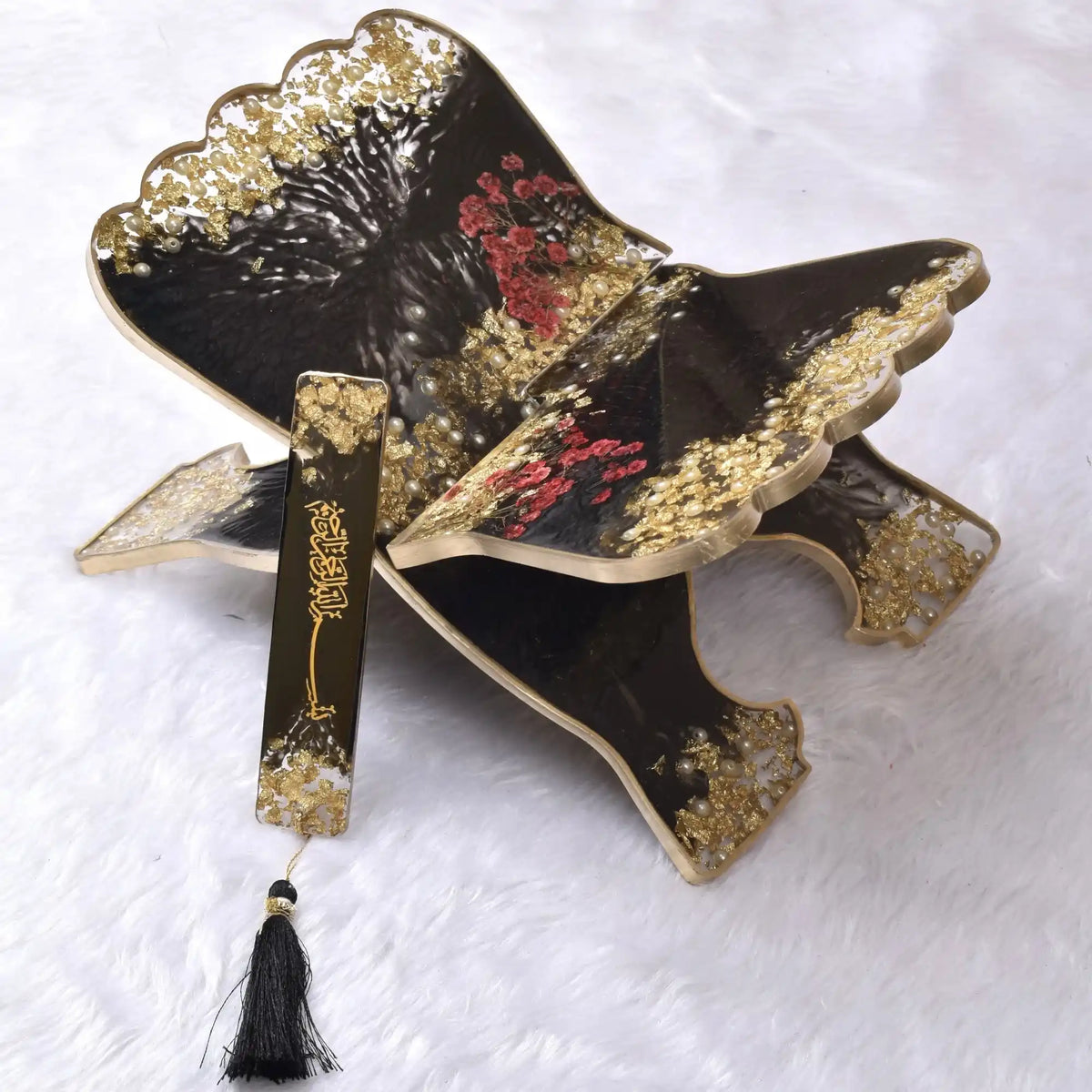 Decorative butterfly with gold accents and a black body on a textured white background