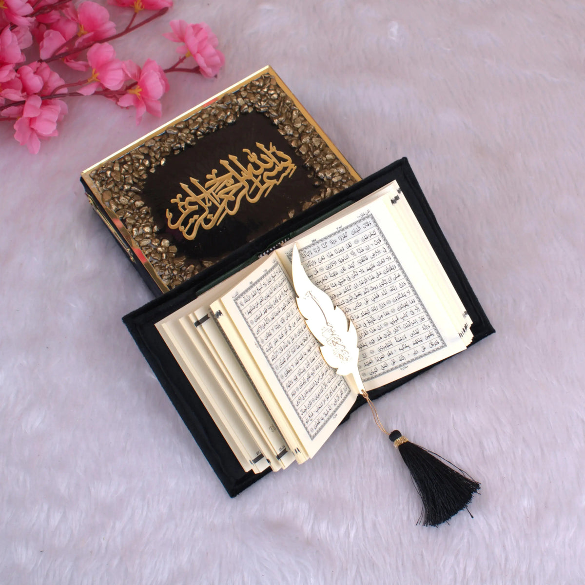 Open Mini Tilawat-e-Quran showing Arabic script pages, paired with gold feather bookmark and luxury black stone-studded box. Perfect Islamic gift set.