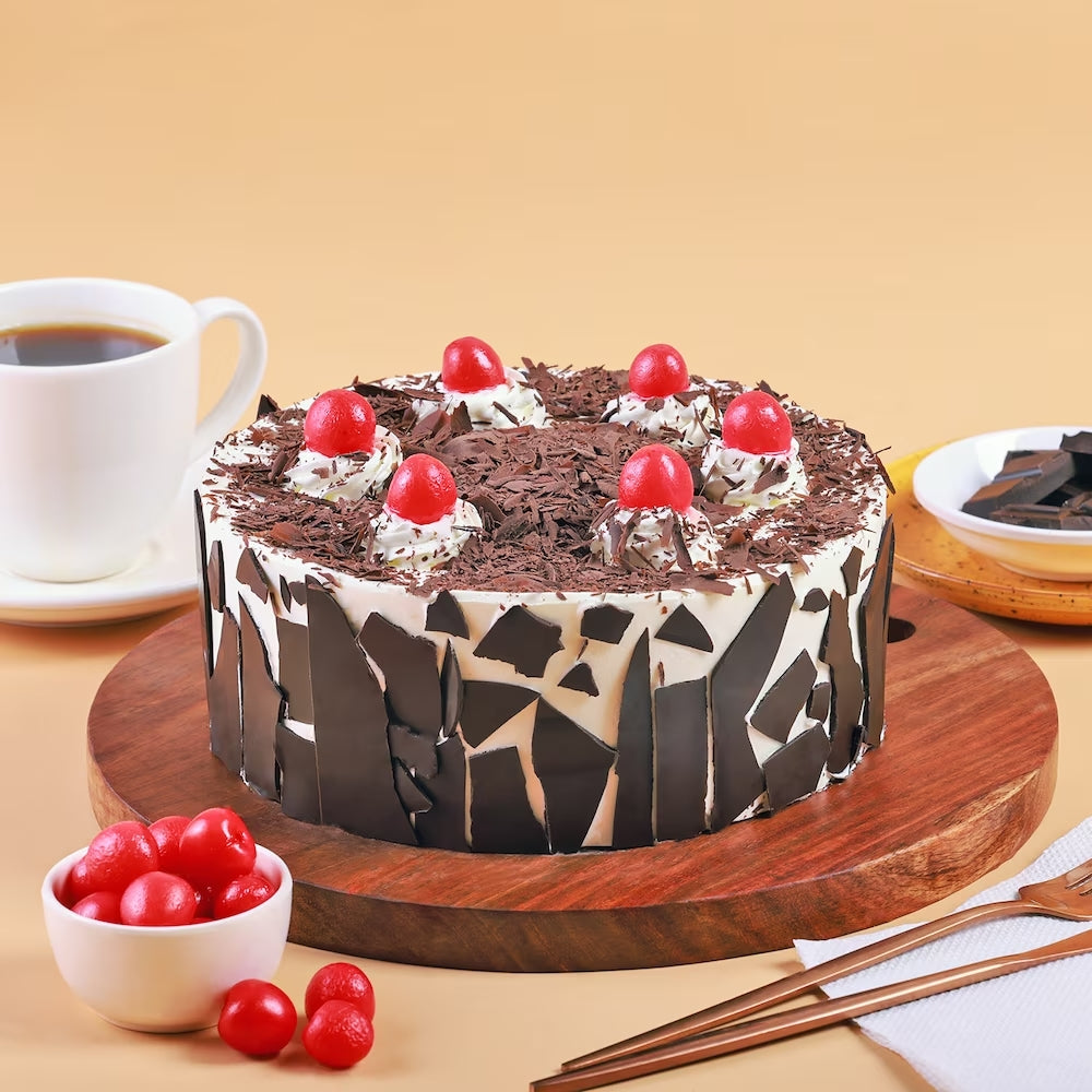 Black Forest Cake Online with rich chocolate layers, whipped cream, and cherries on a wooden board. Ideal for birthdays and same day delivery. Main image