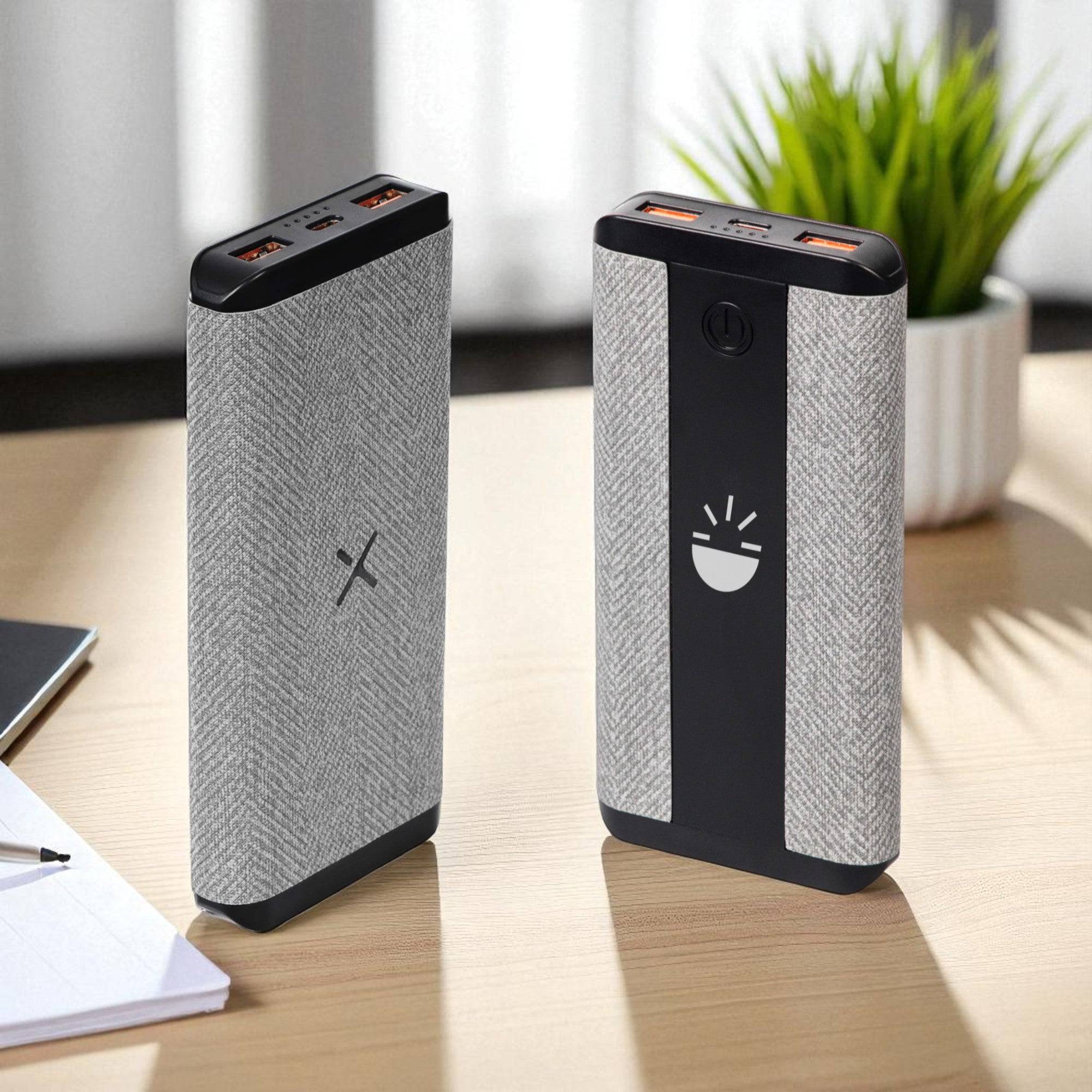 Two power banks on a desk with a plant in the background Main image