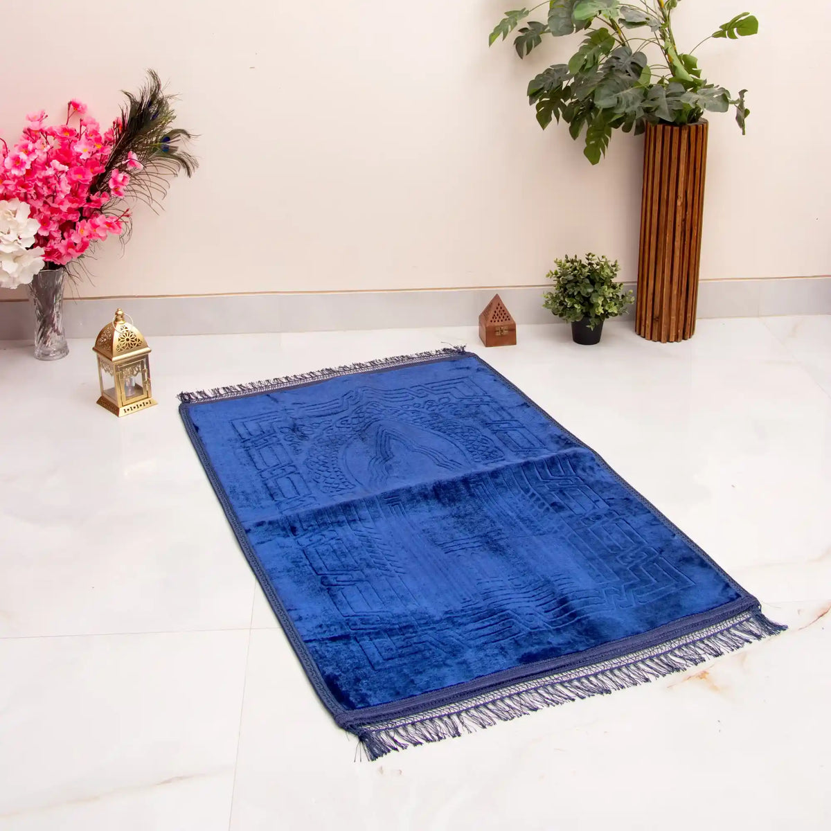 Blue prayer mat on a white floor with decorative items around
