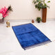 Blue prayer mat on a white floor with decorative items around
