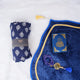 Blue Sajdah Serenity Hamper flat lay on a white fluffy surface, featuring a rolled-up blue printed prayer makhana, a premium blue velvet janamaz, a mini blue velvet Quran, and a matching blue crystal tasbeeh.