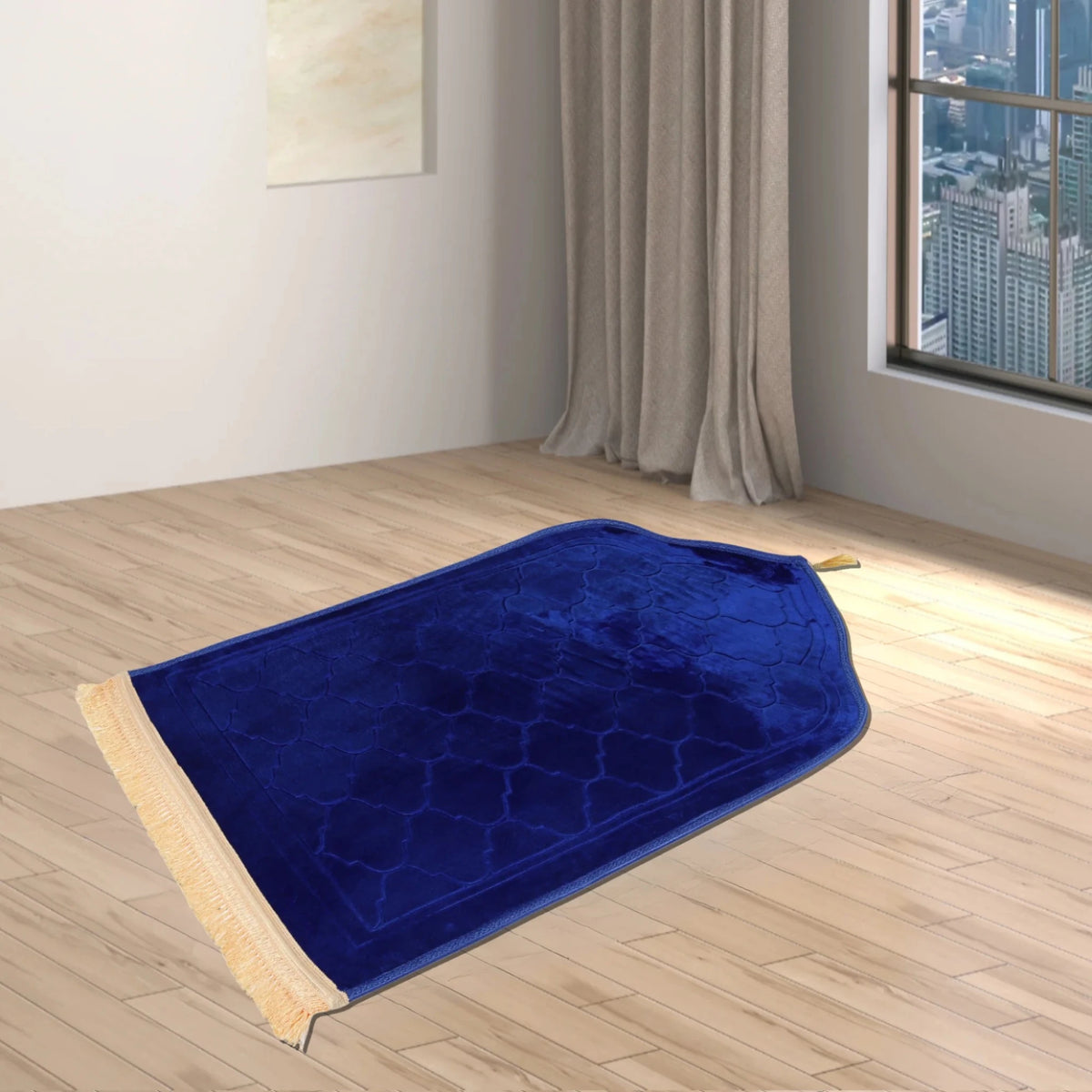 Blue Dome Janamaz with dome-shaped top and golden tassels, placed in a modern room with city view. Personalized prayer mat for Islamic rituals.