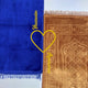Blue prayer mat with 'Hussain' text and yellow heart, next to a brown prayer mat with intricate patterns.