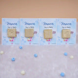 Row of Aqiqah Sweet Blessings Favors with gold-wrapped chocolates on blue personalized cards, great for Aqiqah event giveaways.