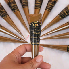 Close-up of a single Bridal Mehndi Cone from Hadiyah Gifting held in hand, labeled 100% natural for safe and easy application.