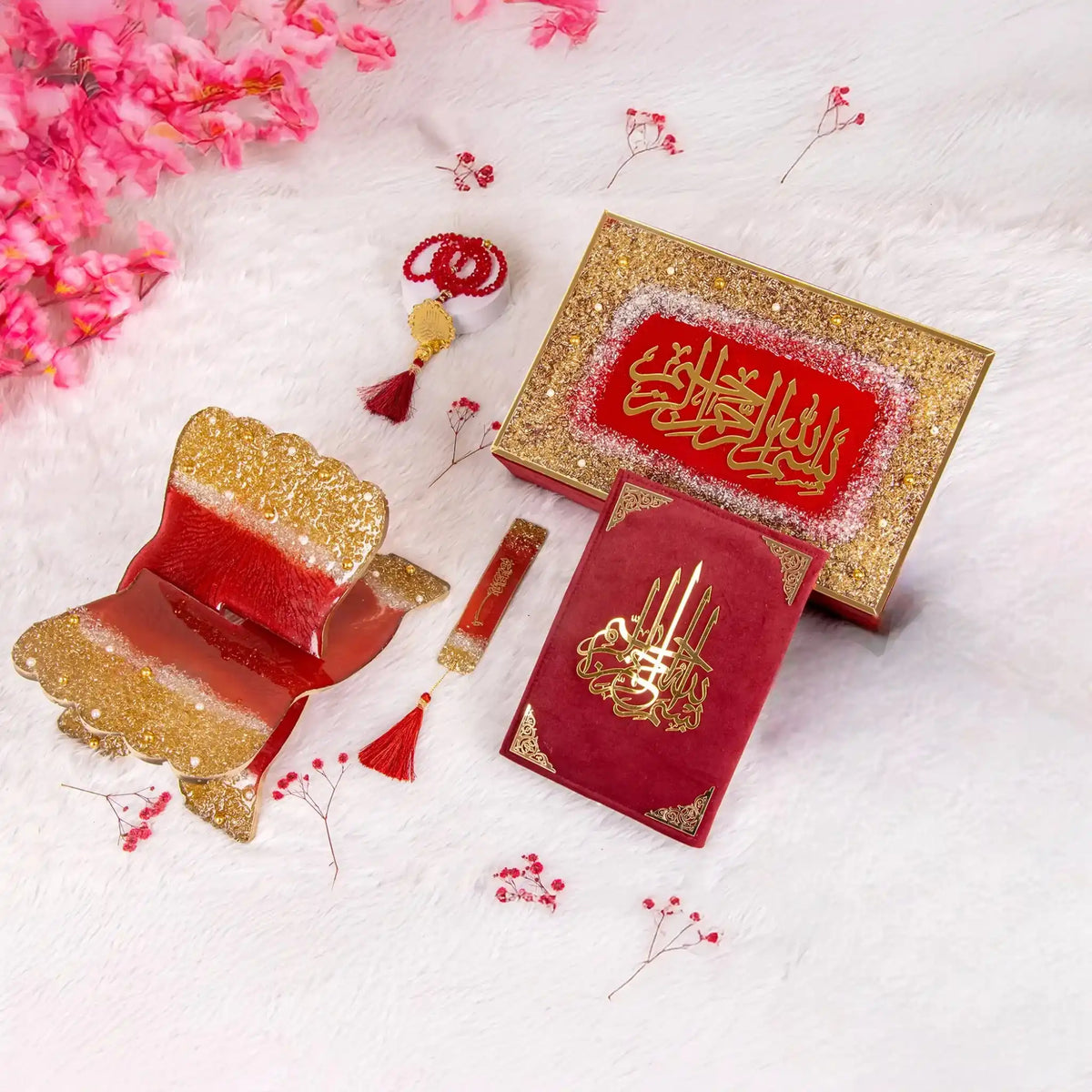 Decorative red and gold items with intricate designs on a white background with pink flowers.