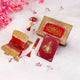 Decorative red and gold items with intricate designs on a white background with pink flowers.