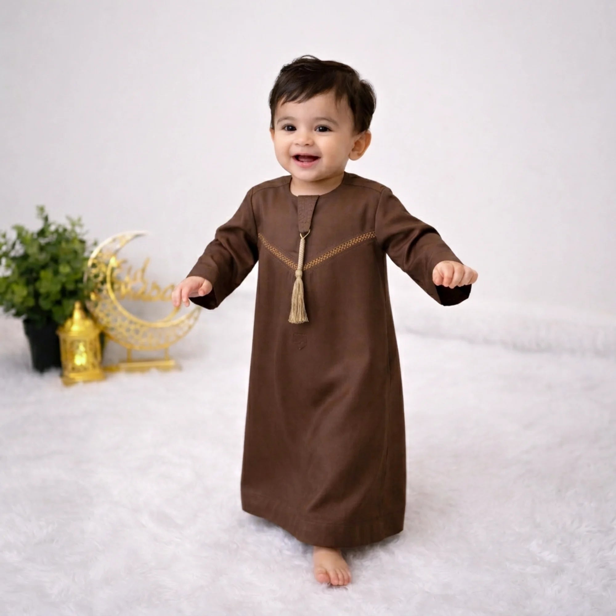 Baby boy in traditional brown thobe for Eid Main image