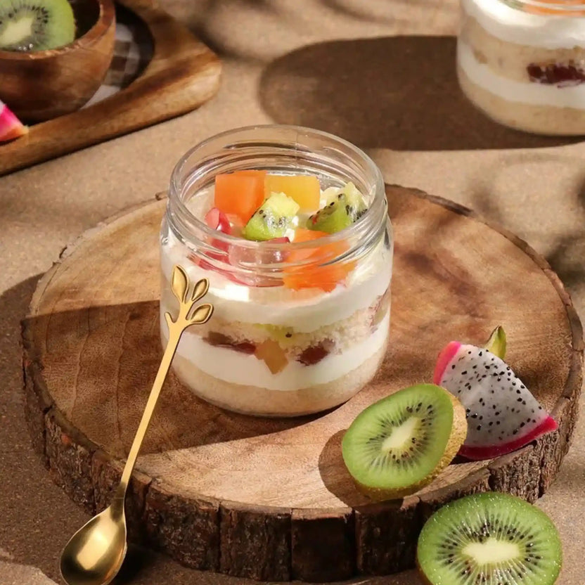 Fruit parfait in a jar on a wooden board with kiwi and dragon fruit slices. Main image