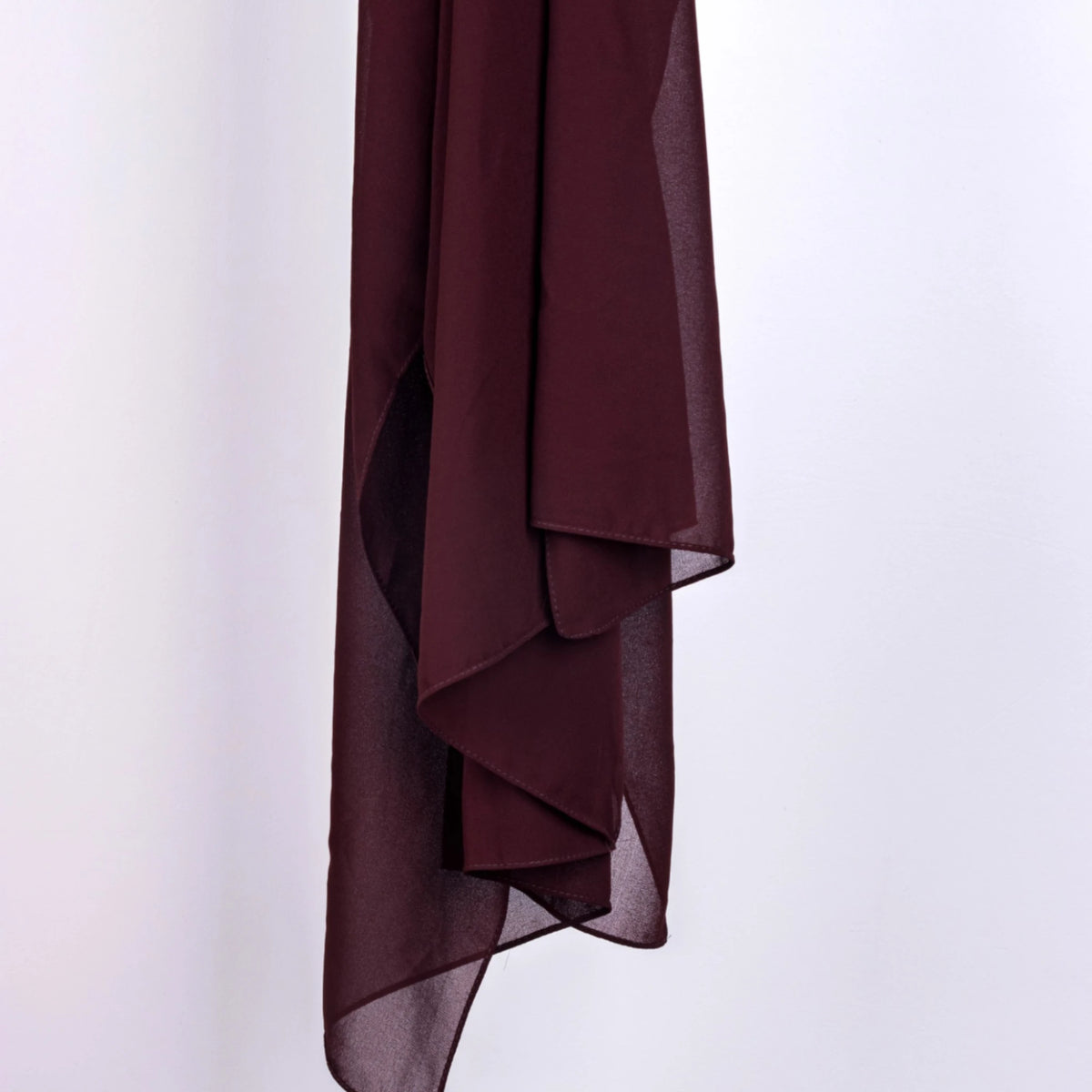 Deep maroon Cocoa Chic Chiffon Hijab hanging to show semi-sheer texture and elegant drape for modest fashion layering.