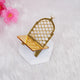 A close-up of a single, empty crescent-shaped gold acrylic date stand resting on a white hexagonal block, set against a soft white fluffy background with blurred pink flowers.