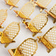Multiple empty crescent-shaped gold acrylic date stands featuring an intricate lattice design and top crescent moon, arranged in neat rows on a plain white surface.