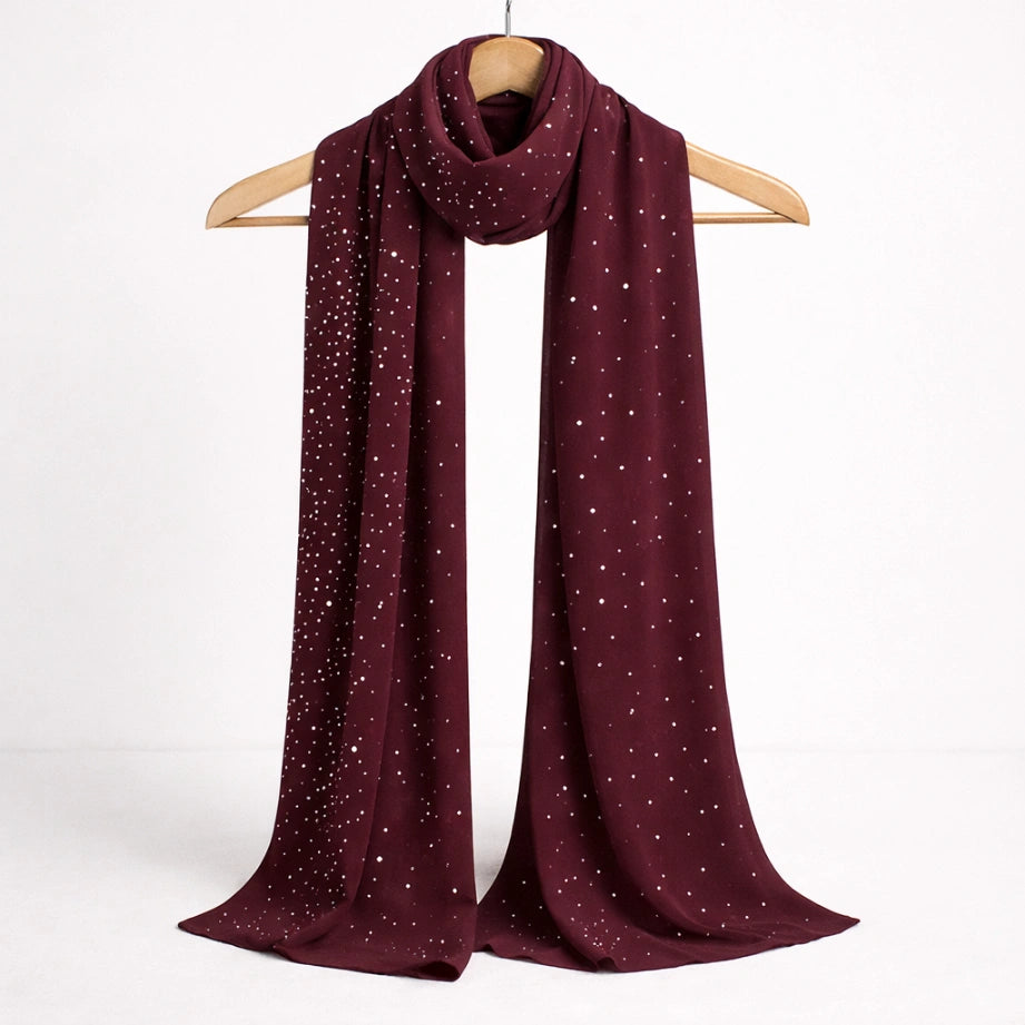 Deep red studded Hijab displayed on a hanger, highlighting its sheer fabric and sparkling stud embellishments.