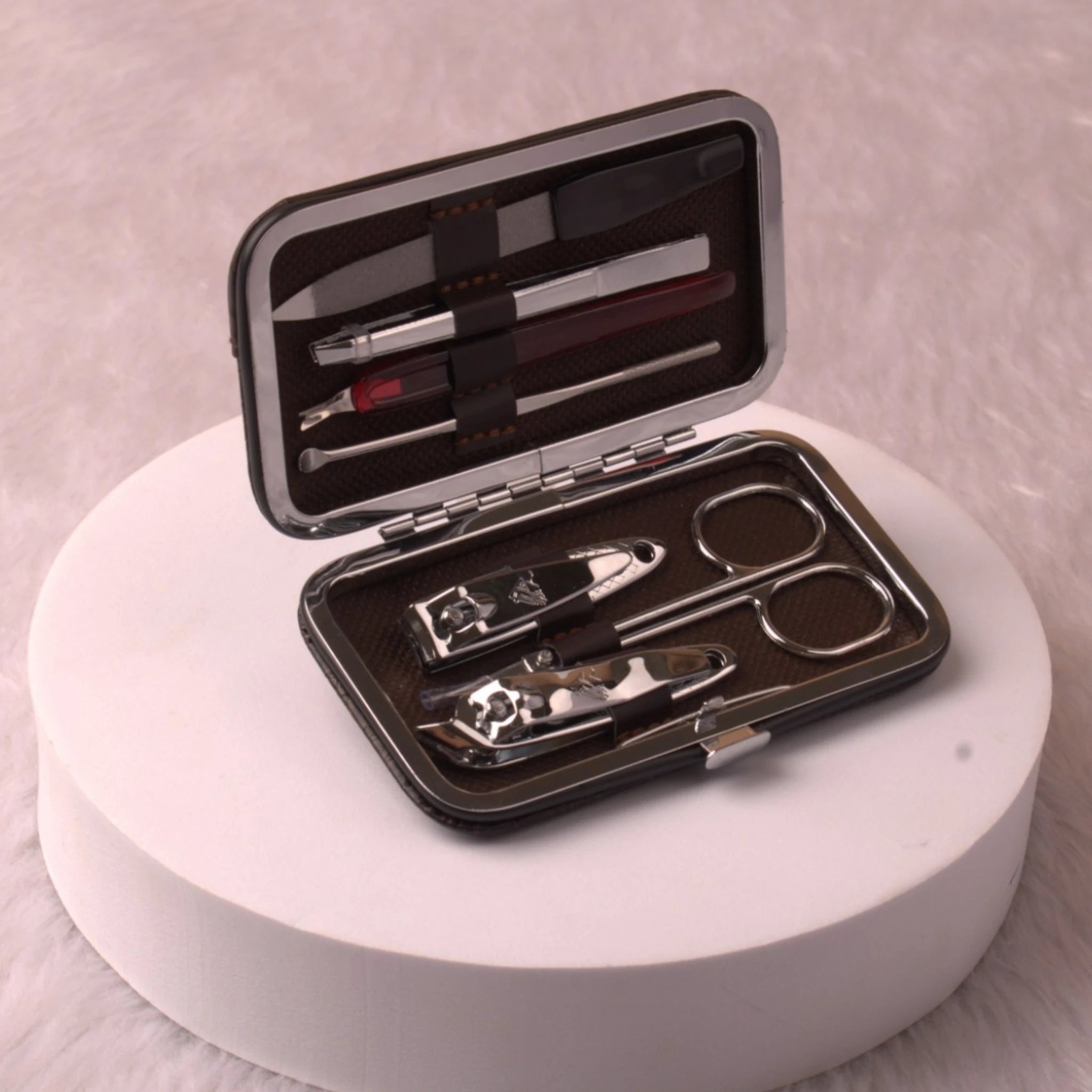 Open personalised travel grooming kit featuring stainless steel nail tools in a brown case. Compact hygiene solution for travel and Umrah.