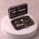 Open personalised travel grooming kit featuring stainless steel nail tools in a brown case. Compact hygiene solution for travel and Umrah.