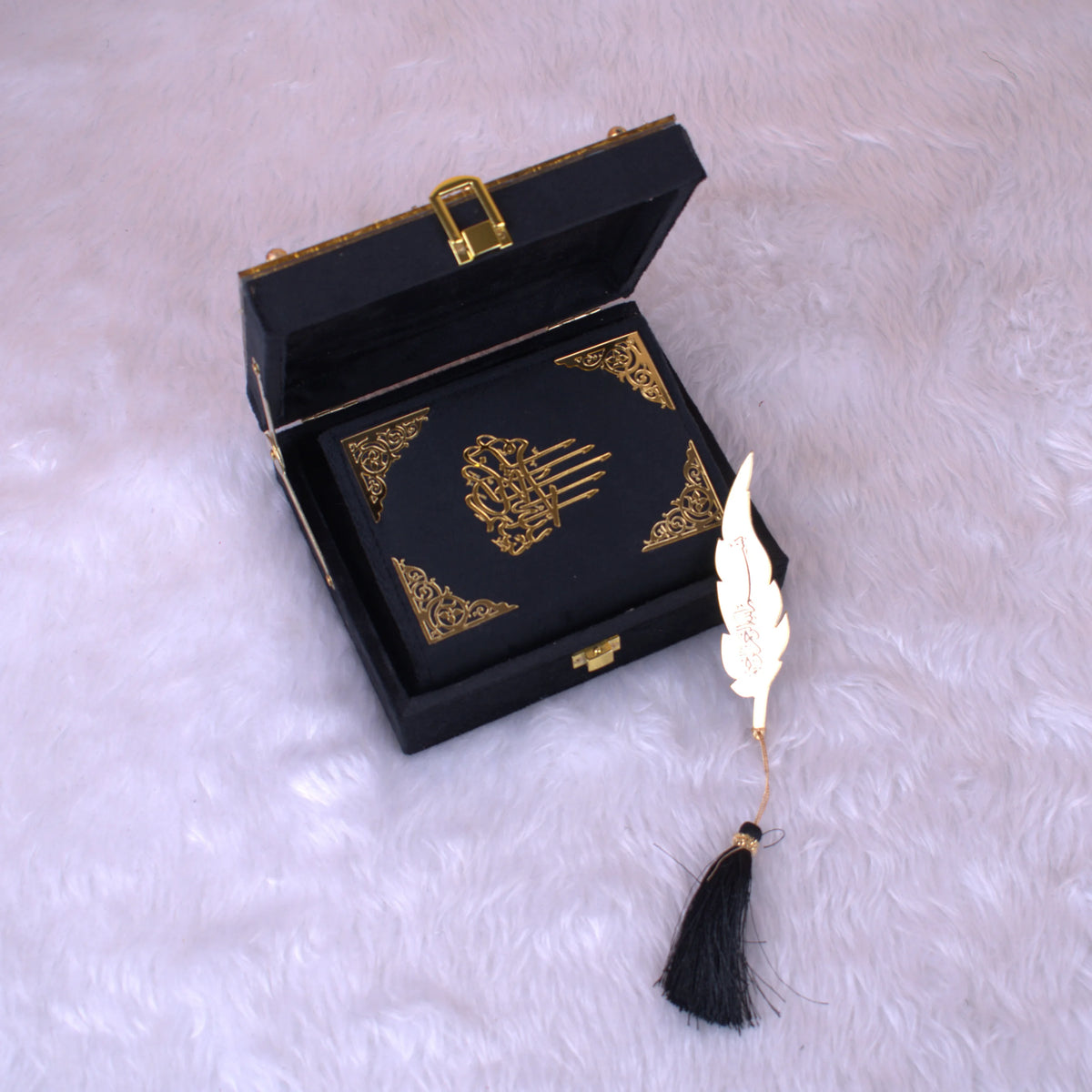 Mini Quran in black velvet with gold detailing, placed inside an open handmade designer box with feather bookmark, perfect for bridal or groom gifts.