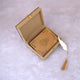 Golden Sequence Mini Tilawat-e-Quran placed inside open velvet designer box with gold feather tassel bookmark beside it, ideal for gifting.