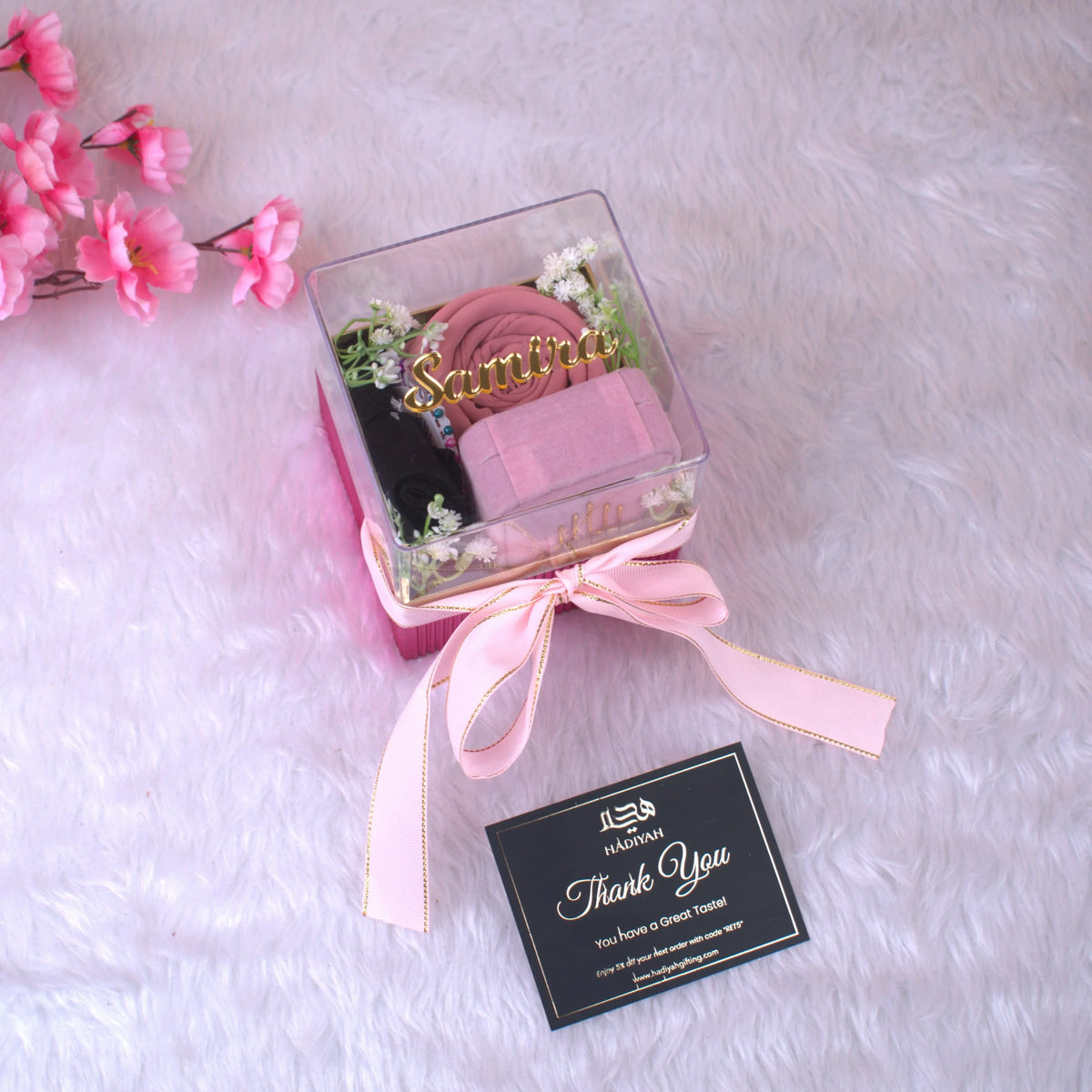 Elegant Pink Hijab Set in a clear-lid box with ribbon, includes hijab, cap, pin, and floral decor—ideal for bridal or Ramadan gifts.