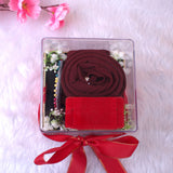 Top view of Red Hijab Combo featuring rolled chiffon hijab, red velvet box, and colorful pins arranged in a clear personalized box.