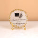 Close-up of personalized Hajj frame with Kaaba artwork and gold stand from Makkah Moments Hamper. Elegant Islamic decor gift item.