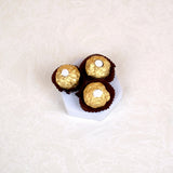 Three Ferrero Rocher chocolates on a hexagonal tray, part of the Makkah Moments Islamic Gift Hamper. Sweet addition to ceremonial gifts.