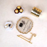 Flat lay of Jannah Journey Hamper - Gift of Faith & Blessings with Hajj frame, Ferrero Rocher chocolates, gold candle, and Kaaba keychain.