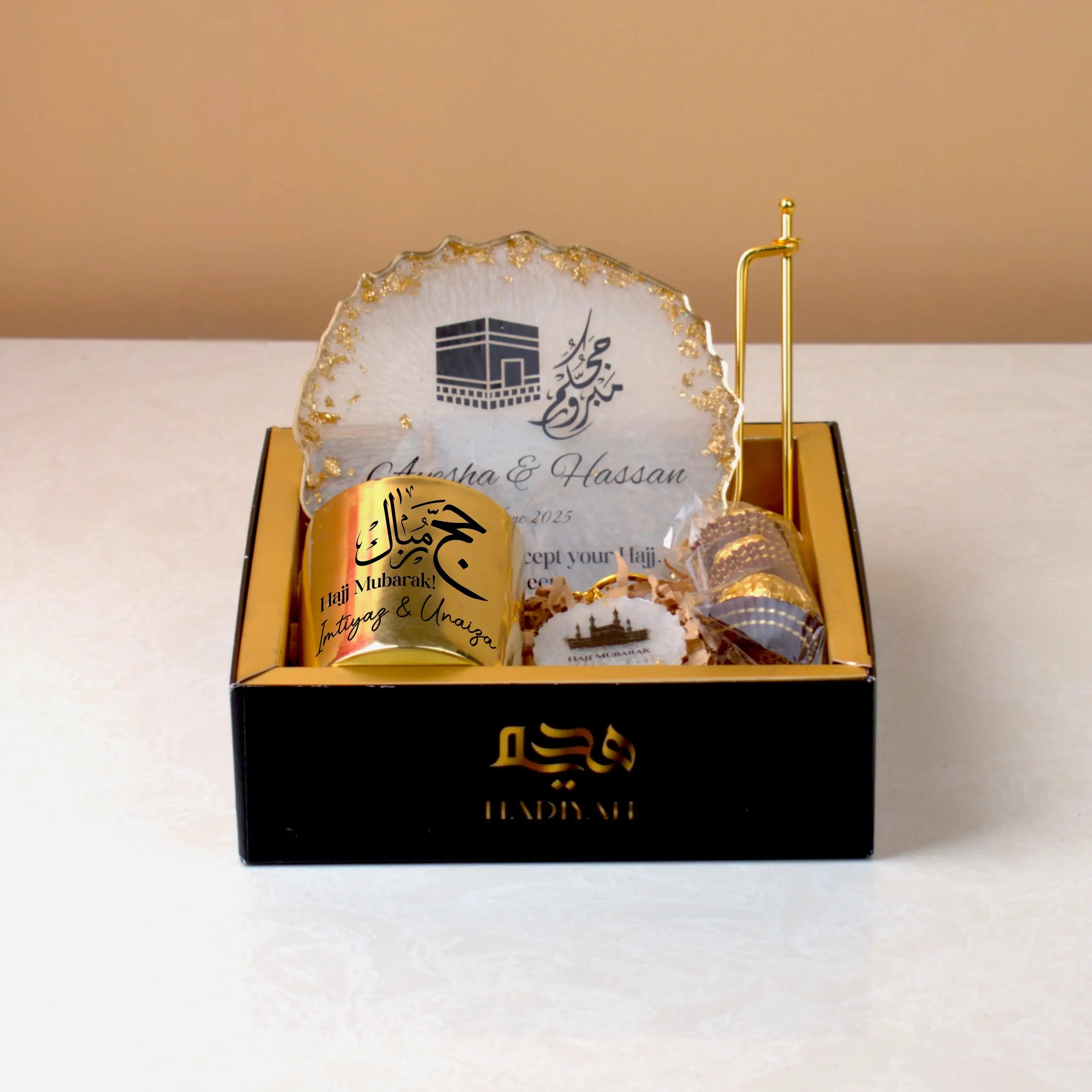 Pilgrim's Promise Hamper - Hajj Gift Hamper with personalized candle, Kaaba-themed frame, and chocolates in a luxury black and gold box. Main image