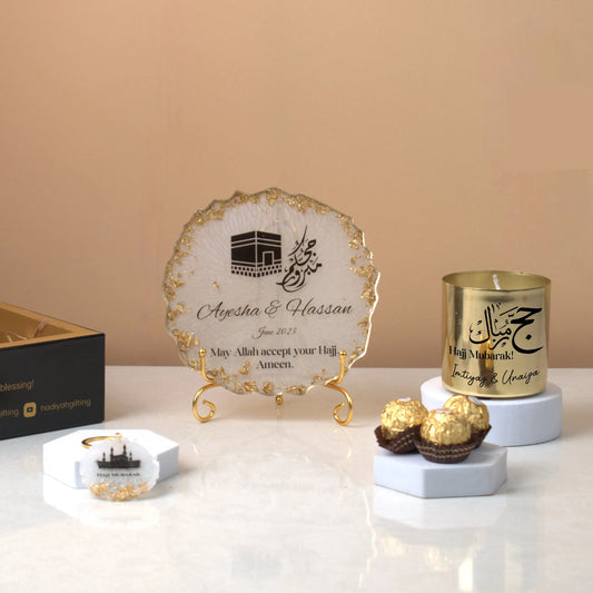 Pilgrim's Promise Hamper - Hajj Gift Hamper featuring gold candle, personalized Hajj frame, chocolates, and Kaaba keychain for Umrah return gifts.