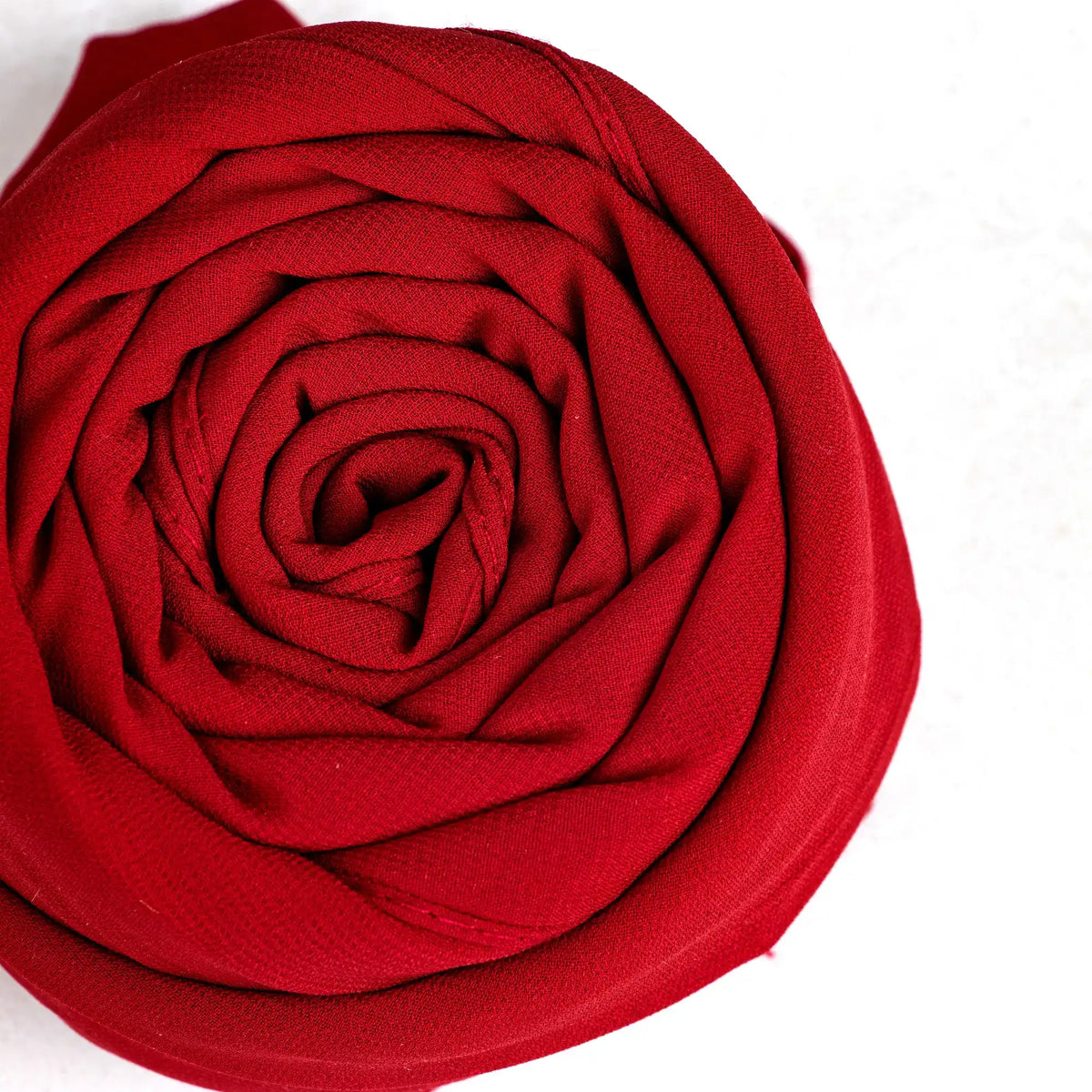 Close-up of a red fabric flower on a white background
