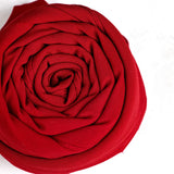 Close-up of a red fabric flower on a white background