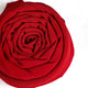 Close-up of a red fabric flower on a white background