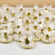 Bulk Mix Dry-Fruit Nikah Favor Gift Trays arranged for a wedding, each wrapped in white mesh with custom gold tags and golden embellishments.