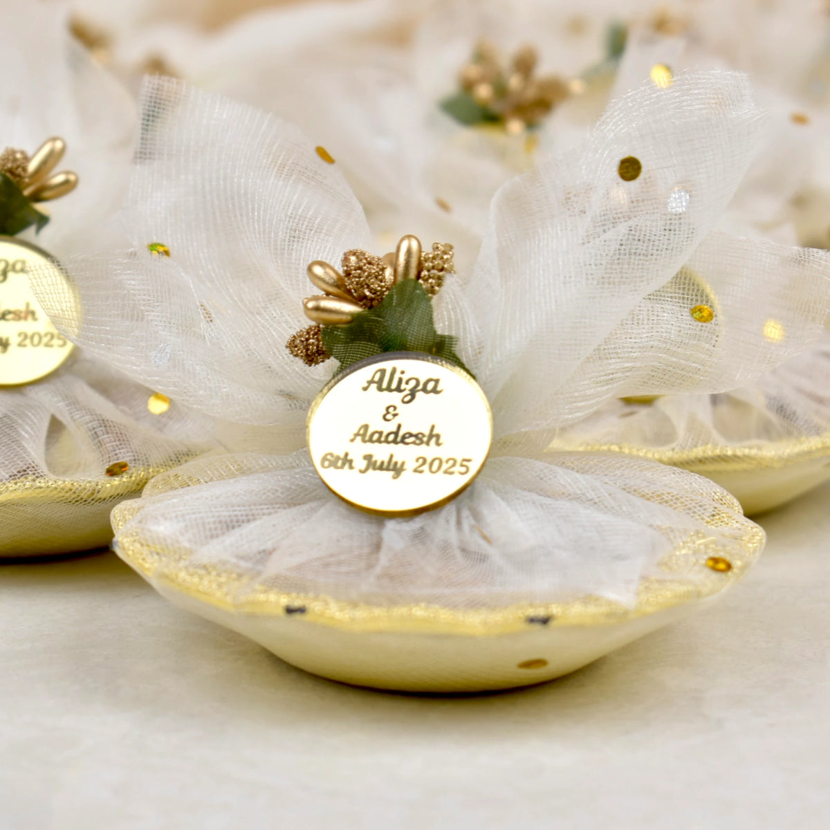 Close-up of Mix Dry-Fruit Nikah Favor Gift Tray featuring a gold tag with names and date, wrapped in elegant white net with gold details.