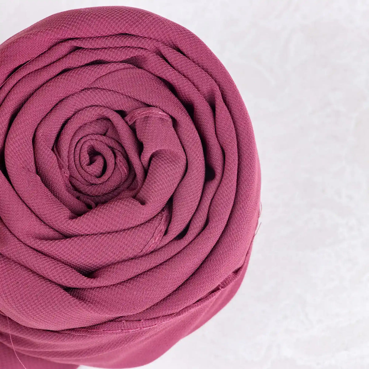 Close-up of a pink fabric roll on a white background
