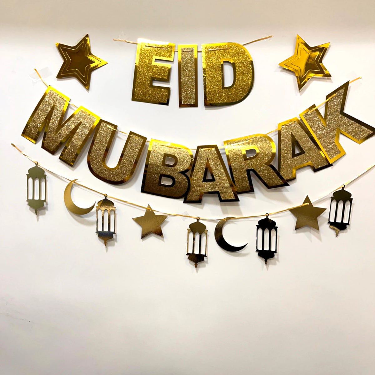 EID Mubarak Banner Decor in gold glitter with stars, moons, and lanterns. Premium quality festive decoration for Eid celebrations at home or events.