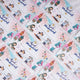 A flat lay view of multiple white Eid Mubarak printed paper envelopes with festive cartoon designs, scattered diagonally across a soft white textured background.