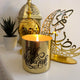 Eid Mubarak Scented Candle with black script on gold jar, glowing beside festive Ramadan decor. Elegant home fragrance for Eid celebrations.