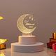 Personalized Eid Mubarak LED lamp emitting a warm glow, featuring an intricate crescent moon design and the name "Saba", displayed on a white cylindrical base.