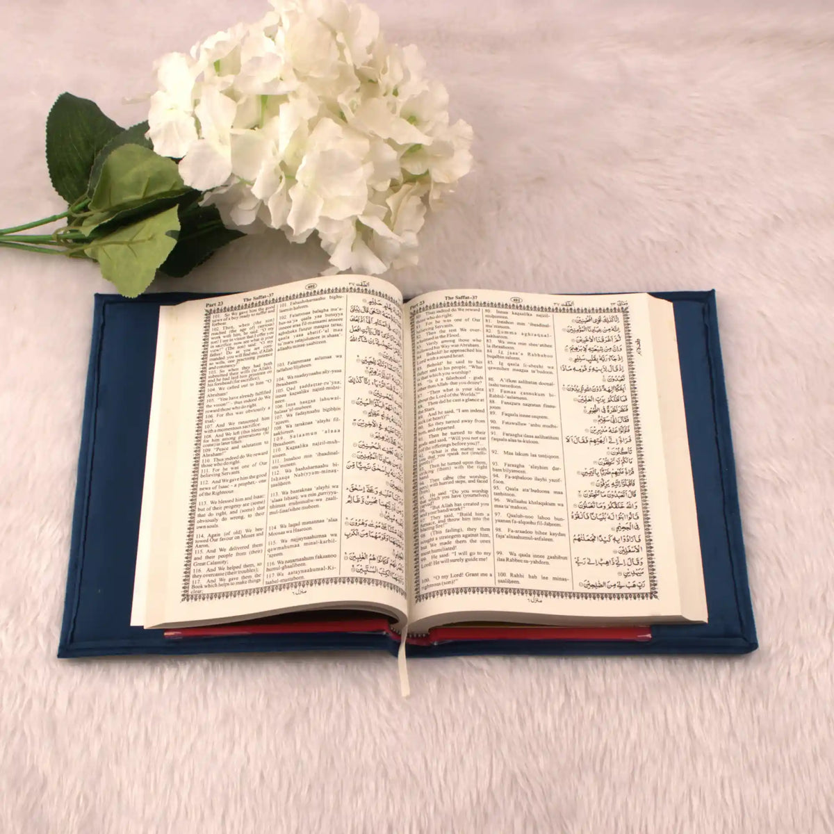 Open book with floral decoration on a light surface