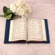 Open book with floral decoration on a light surface