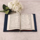 Open book with floral arrangement on a light surface