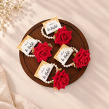 Haldi e Haya Floral Favors featuring red rose hand bracelets with pearl bands and personalized 'Aliya ki Haldi' cards, ideal for wedding celebrations.