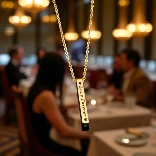 Gold Bar Pendant Necklace engraved with 'Love Forever' in a romantic restaurant setting, ideal personalized gift for anniversaries or birthdays.