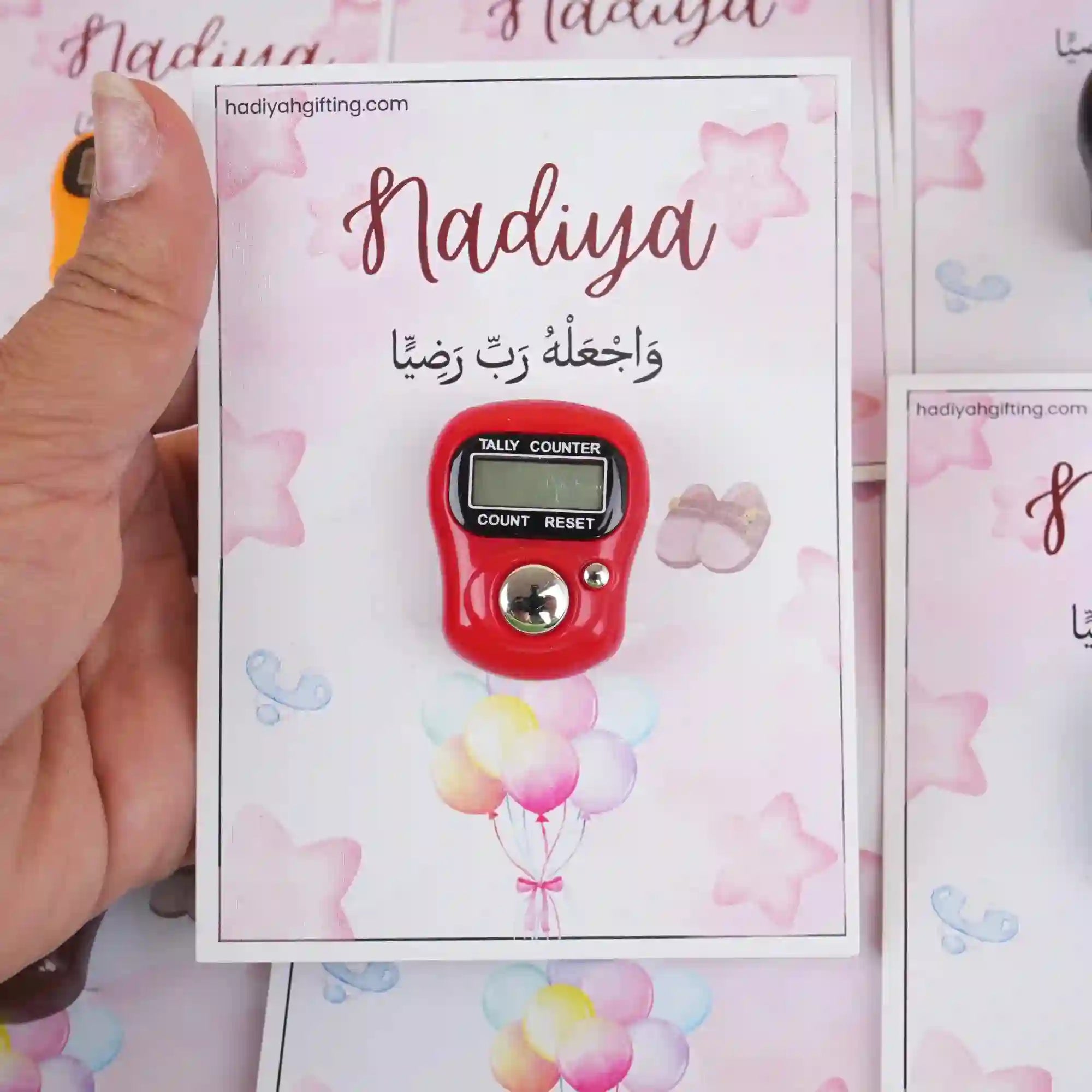 Red digital Aqiqah Tasbeeh Favor on a pink personalized card with name Nadiya, ideal for Islamic wedding or baby ceremony gifts.