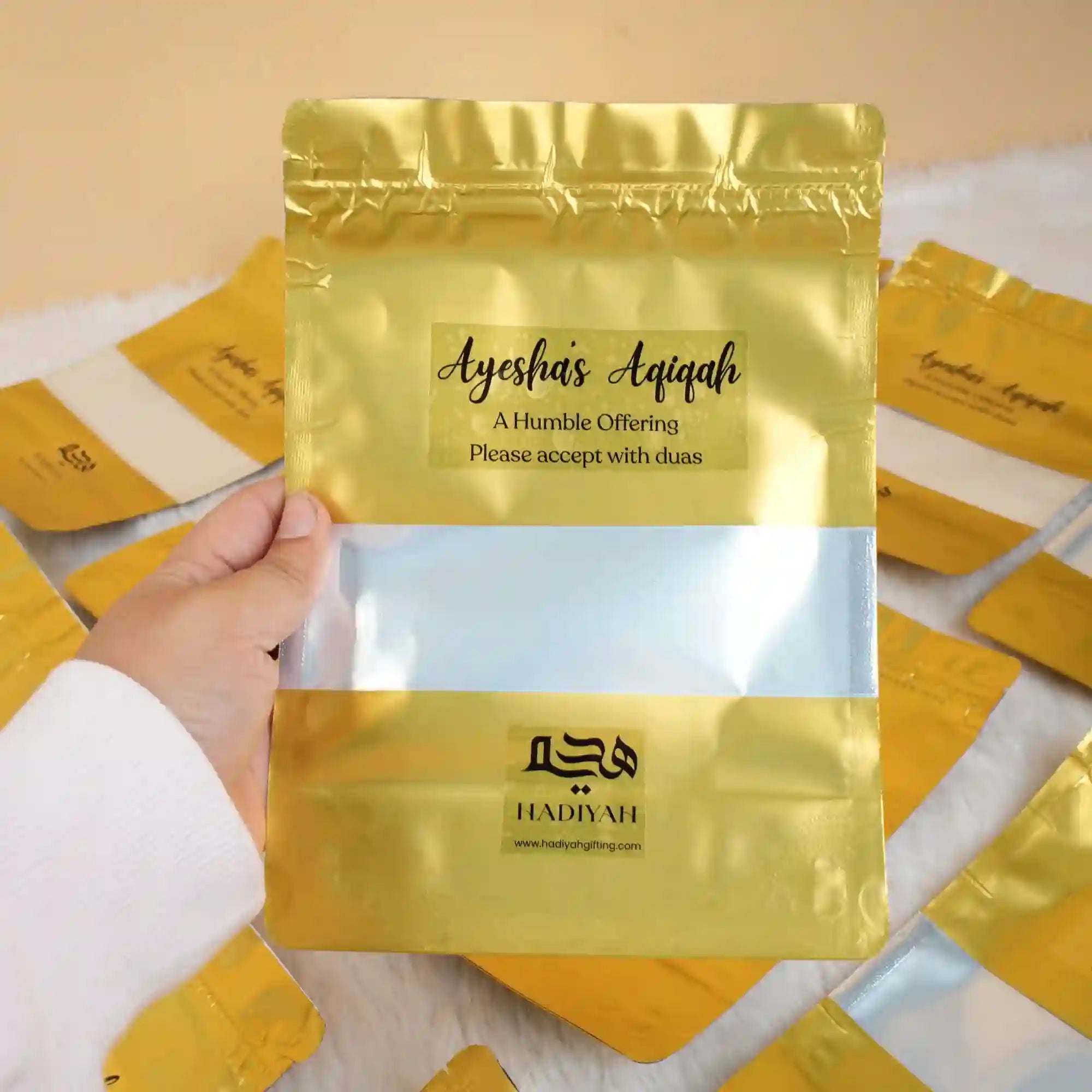 Custom Aqiqah Meat Packet with gold and silver pouch design, labeled 'Ayesha's Aqiqah' for wedding favors and food gift baskets. Main image