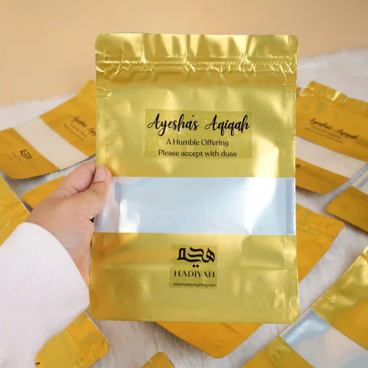 Custom Aqiqah Meat Packet with gold and silver pouch design, labeled 'Ayesha's Aqiqah' for wedding favors and food gift baskets.