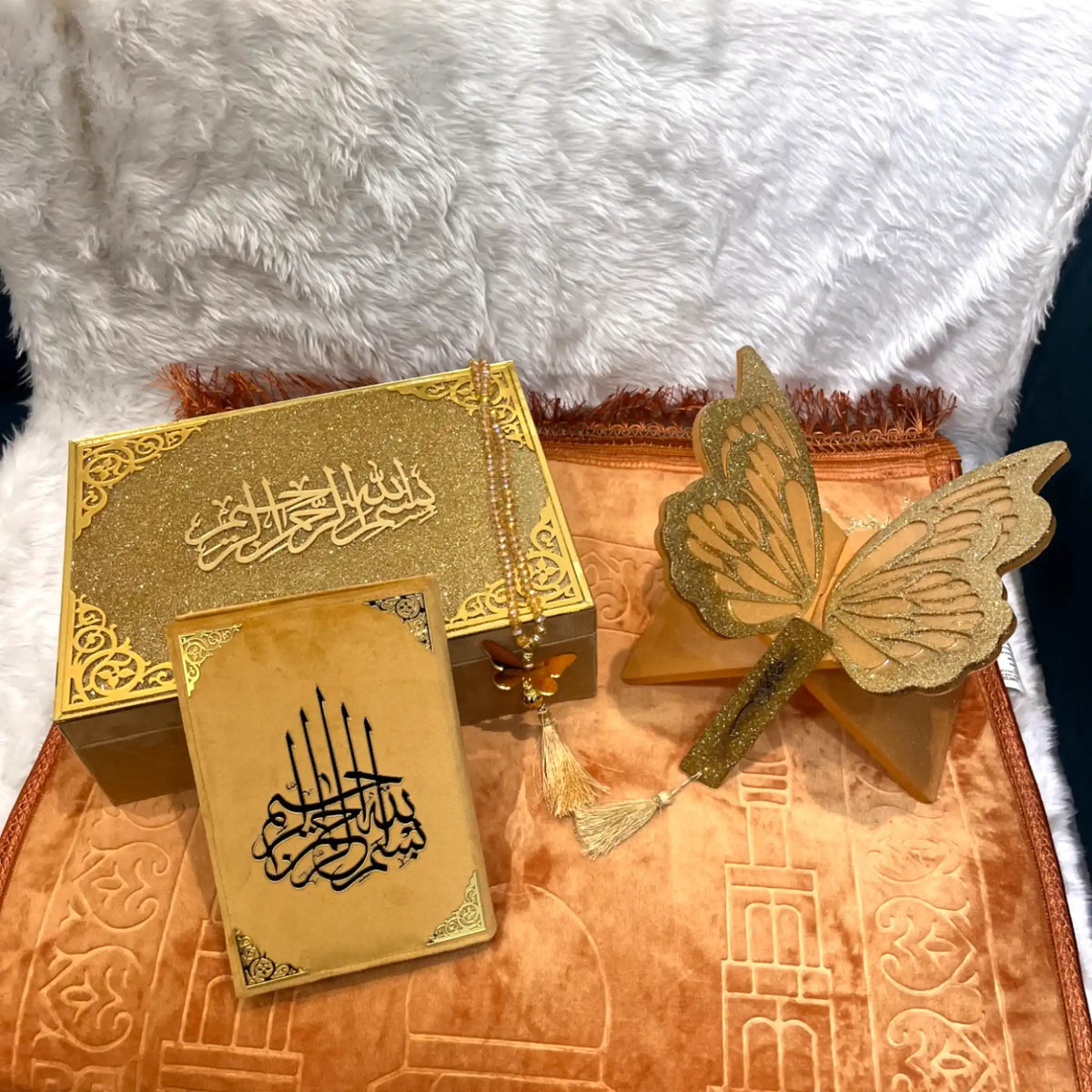 Decorative set with gold butterfly,祈祷文 (prayer text) card, and decorative box on a textured surface.